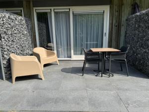 a patio with chairs and a table and chairs at Prins Prachtig Amelander Kaap 97 in Hollum
