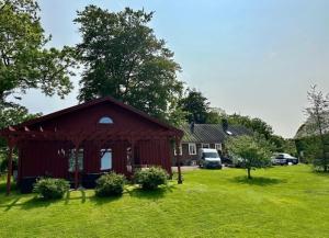 a red barn in a field of green grass at Gunnegårds gästhus in Fleninge