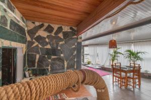 a room with a stone wall and a table and chairs at Oaxaca Venado in Agaete