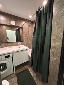 a bathroom with a shower curtain and a sink at Three rooms on Arbat in Shymkent