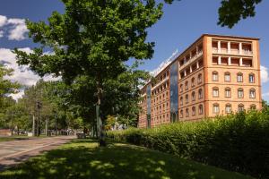 a tree in the grass next to a building at Best Western Plus Congress Hotel Yerevan in Yerevan