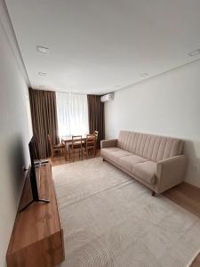 a living room with a couch and a table at Three rooms on Arbat in Shymkent