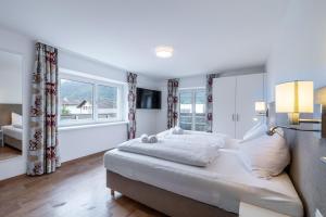 a bedroom with a large bed and two windows at Schwarzhans Appartments in Bludenz +39 photos