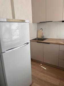 a kitchen with a white refrigerator and a sink at Three rooms on Arbat in Shymkent
