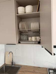 a kitchen cabinet with plates and dishes in it at Three rooms on Arbat in Shymkent +18 photos