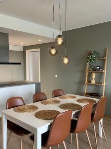 a dining room with a white table and chairs at Tikka Apartments in Jyväskylä