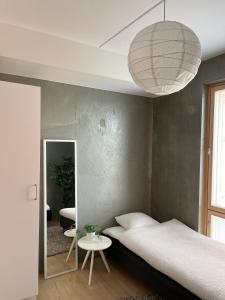 a bedroom with a bed and a table and a lamp at Tikka Apartments in Jyväskylä