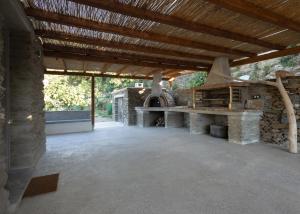 an outdoor kitchen with a stone oven in a patio at Falcon Eyes- Panoramic stone house in Andros