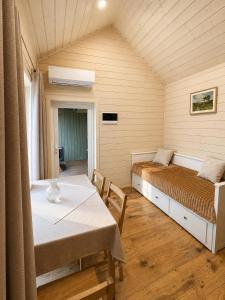 a bedroom with a bed and a table and chairs at Atpūtas mājas Leiksnīte in Vaikulāni