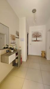 a large white room with a table and a tree on the wall at Mediterraneum in Sannicola +25 photos
