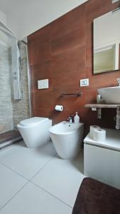 a bathroom with two white toilets and a sink at Mediterraneum in Sannicola