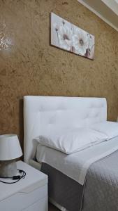 a bedroom with a white bed and a picture on the wall at Mediterraneum in Sannicola