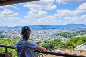 a woman standing on a balcony looking at a city at Mikasa in Nara +55 photos