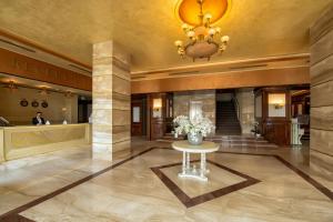 a lobby with a vase of flowers on a table at Hotel Roman by Dumbrava Business Resort in Roman