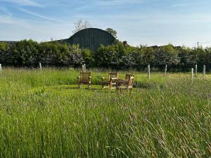 two chairs and a table in a field of tall grass at Keepers Cottage in Warminster