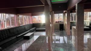 a waiting room with black leather seats and windows at Bright Moon Hotel limited in Enugu