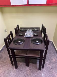 a black table with chairs and plates and glasses at wonderful stays in Tirupati