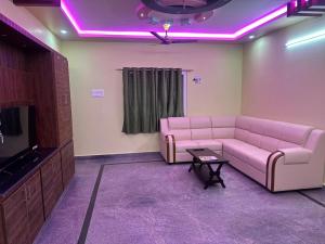 a living room with a pink couch and a tv at wonderful stays in Tirupati