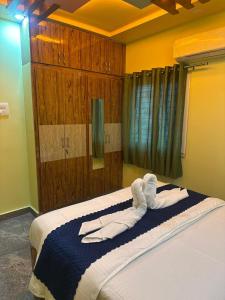 a bedroom with a large bed with white sheets at wonderful stays in Tirupati