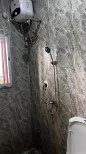 a shower in a bathroom with a toilet at Bright Moon Hotel limited in Enugu