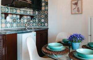 a kitchen with a table with bowls and plates on it at Corfu Glyfada Beach Apartment 25 in Glyfada