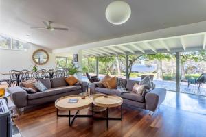 a living room with two couches and a table at Emerald Cove I Private Properties in Denmark