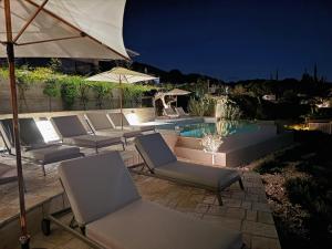 a group of chairs and an umbrella next to a pool at Turtle Home in Skala