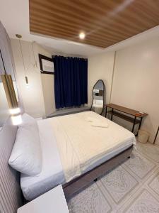 a bedroom with a large white bed and a table at BMF Homestay Jacuzzi Villa 2 in Sagcahan