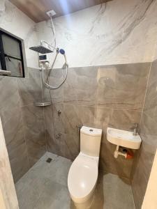 a bathroom with a toilet and a sink at BMF Homestay Jacuzzi Villa 2 in Sagcahan +9 photos