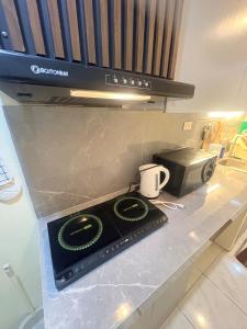a counter top with a microwave and a coffee mug at BMF Homestay Jacuzzi Villa 2 in Sagcahan