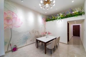 a dining room with a table and flowers on the wall at The Pivot Suite Ben Thanh - District 1 in Ho Chi Minh City