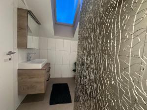 a bathroom with a sink and a wall with a window at Honor-Penthouse in Linz +35 photos