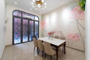 a dining room with a table and chairs and flowers on the wall at The Pivot Suite Ben Thanh - District 1 in Ho Chi Minh City +47 photos