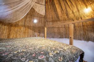 a bedroom with a bed with a thatched ceiling at Oaxaca Caracol in Agaete +19 photos