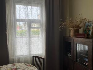 a room with a window with a table and a chair at Vekšin Old Town & Promenade Apartment, Haapsalu in Haapsalu