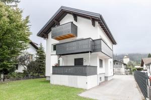 a white house with black balconies on it at Schwarzhans Appartments in Bludenz
