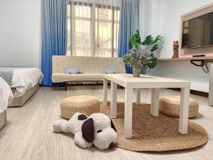 Ein Wohnzimmer mit einem Tisch und einem Stofftier auf dem Boden. in der Unterkunft PiR2 House in Tainan