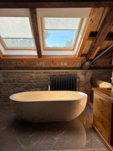 a large bath tub in a bathroom with two windows at Pension U Hastrmana in Prague +70 photos
