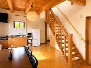 a kitchen and dining room with a table and a staircase at Hamabun テラスでBBQ 湖まで徒歩5分 無料駐車場3台 in Takashima
