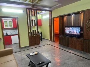 a living room with a tv and a table at wonderful stays in Tirupati