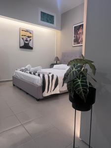 ein Schlafzimmer mit einem Bett und einer Pflanze in der Unterkunft Rea Harmony in Kalamata