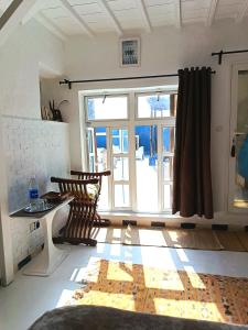 a living room with a large window and a table at La Maison des Artistes in Essaouira