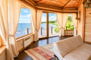 a living room with a couch and large windows at Secret River Rooms in Pereiaslav-Khmelnytskyi