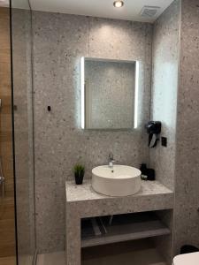 a bathroom with a sink and a mirror at Luxor Suites Olimpou in Thessaloniki +6 photos