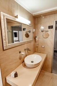 a bathroom with a sink and a mirror at Hotel Roman by Dumbrava Business Resort in Roman