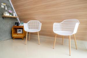 two white chairs in a room with a table at Green Tara Valley Ubud by Betterplace in Ubud
