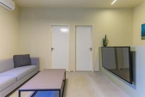 a living room with a couch and a tv at Capri 2-BR Apartment In Bahsa Batroun in Batroûn +15 photos