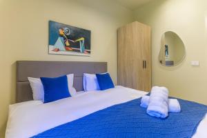 a bedroom with a large bed with blue and white sheets at Capri 2-BR Apartment In Bahsa Batroun in Batroûn