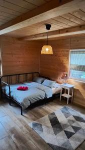 a bedroom with a bed in a wooden room at Leśne Doliny 38 in Zwiartów