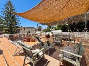 a patio with chairs and tables and a large umbrella at Casita Pablo in Agua Amarga